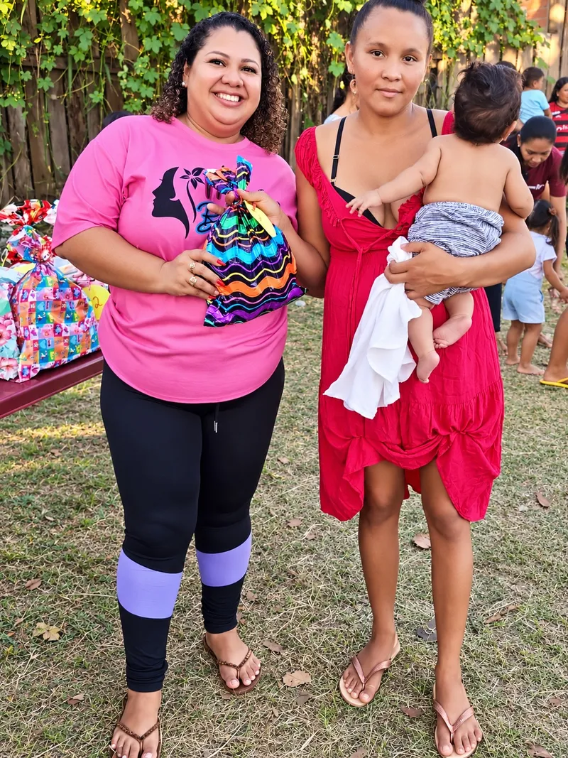 Duas mulheres com um bebê durante a celebração do Dia das Mães